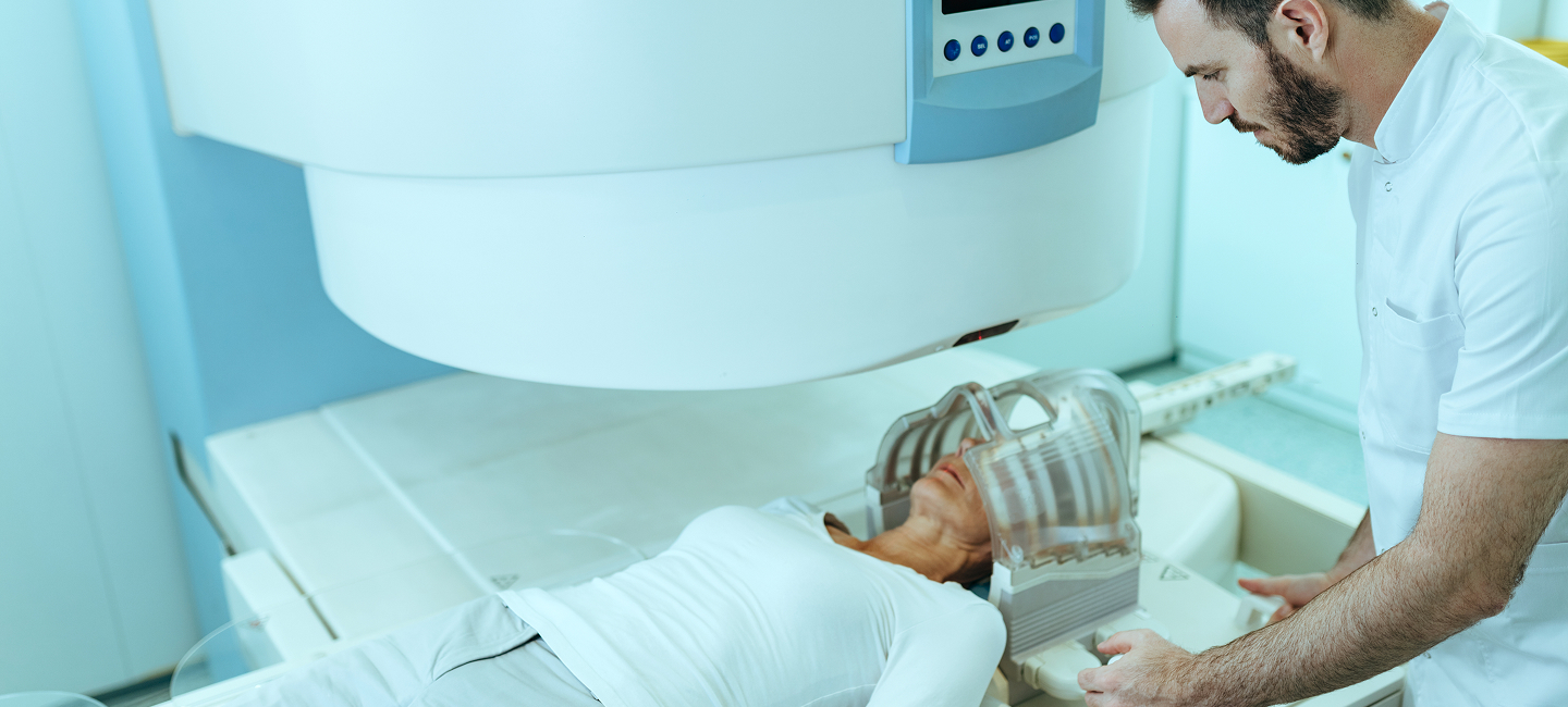 Un técnico prepara una máquina de resonancia magnética para un paciente que está esperando una resonancia magnética cerebral